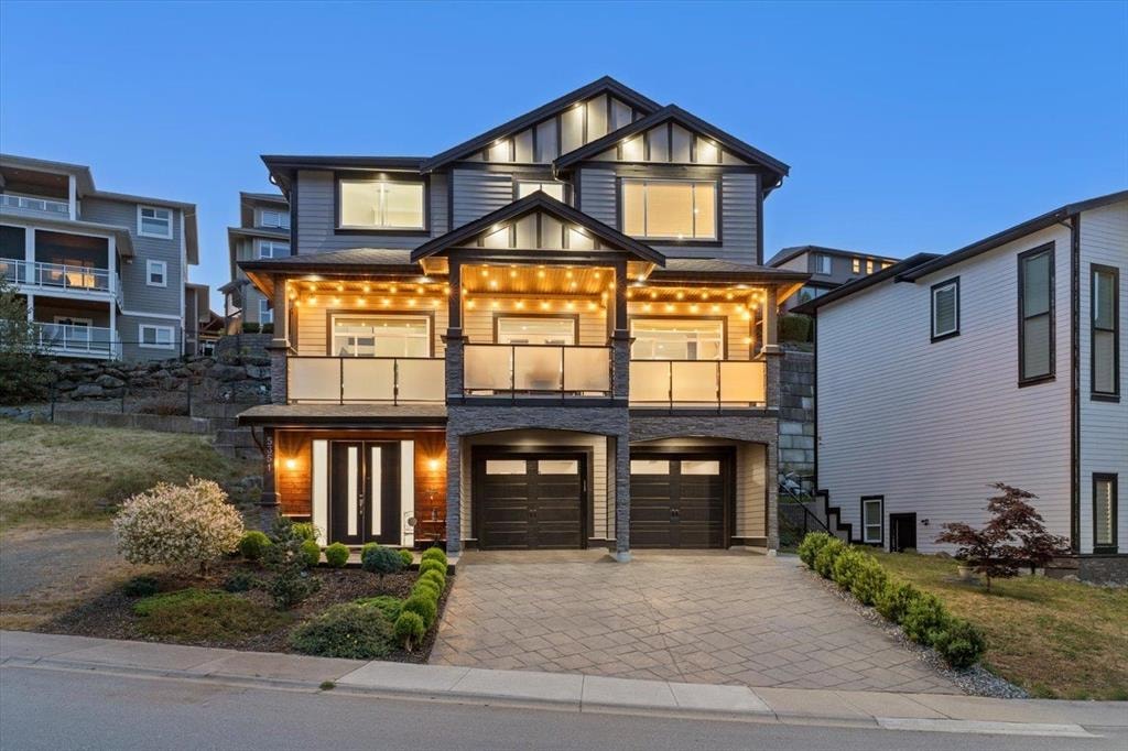 Twilight exterior of the luxury home at 5351 Abbey Crescent in Promontory, Chilliwack, with warm string lights over the entry patios